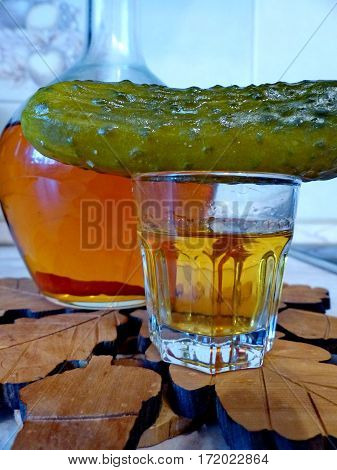 Home tincture honey with pepper (Fortress 45 degrees). Pickled cucumber, decanter with tincture. Closeup. Natural food. Traditional Russian cuisine.