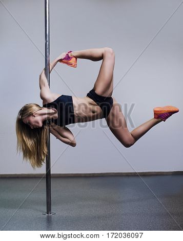 Beautiful Young Woman Holding A Pose In A Pole Fitness Class