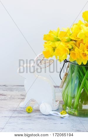 Easter eggs hunt - white rabbit with eggs and daffodils bouquet