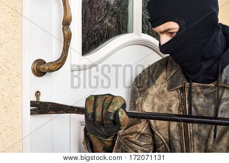 Burglar trying to break into a house with a crowbar