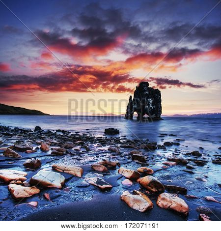 Hvitserkur is a spectacular rock in the sea on the Northern coast of Iceland. Legends say it is a petrified troll. On this photo Hvitserkur reflects in the sea water after the midnight sunset.