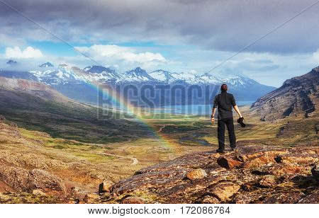 Fantastic views of the mountains and a little rain and a rainbow in Iceland. Colorful colors. Dramatic cumulus clouds. The man considers beautiful landscapes. Europe.