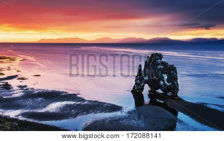 Hvitserkur is a spectacular rock in the sea on the Northern coast of Iceland. Legends say it is a petrified troll. On this photo Hvitserkur reflects in the sea water after the midnight sunset.