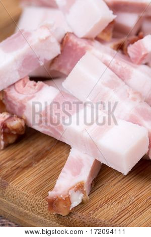 Sliced chopped bacon on the kitchen wooden board.