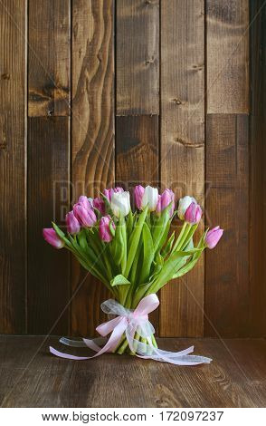 beautiful bouquet with pink and white tulips standing on wooden background