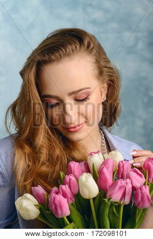 Close-up portrait of pretty woman with flowers near her face