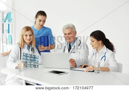 Team of doctors exploring roentgenogram at table