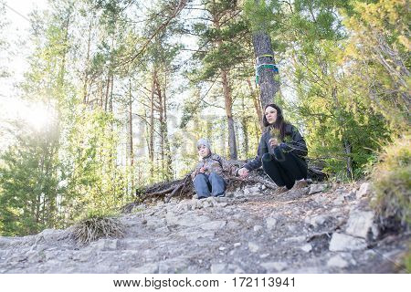 Young mother walking with her son outdoors in autumn