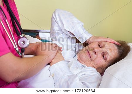 Picture of a bedridden old woman having a headache