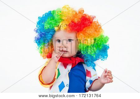 Children clown with a red nose multicolored wig in with balls. On a white background.
