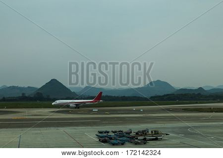 airplane landing to Chongqing airport runway in China with cloudy mountain background