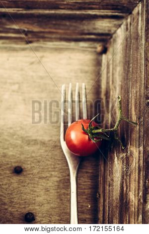 Food background. wood with fork and tomao