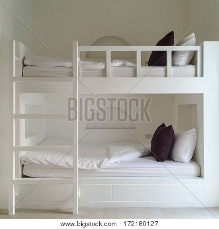 Clean hotel room with wooden bunk beds. Vintage effect style pictures.