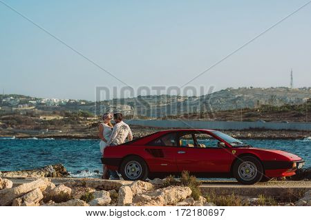 Young Couple Staying In Back Of The Red Ferrari