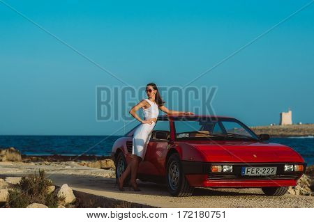 Young Beautiful Girl In Sunglasses Posing Near The Red Ferrari