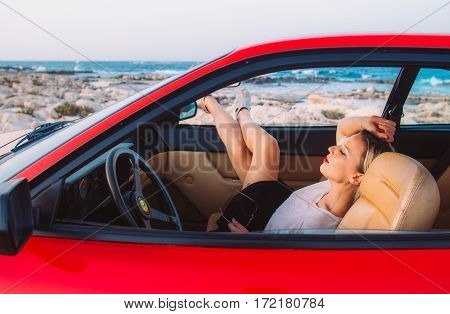 Woman Sitting On The Front Seat Of The Red Ferrari With Legs In The Window