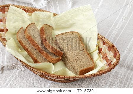 Sliced of rye bread in small wicker basket.