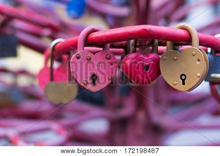 Beautiful metal locks in the form of heart on the bridge