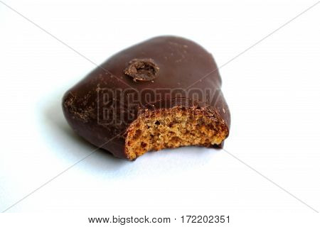 Chocolate gingerbread heart with a bite mark on a white background