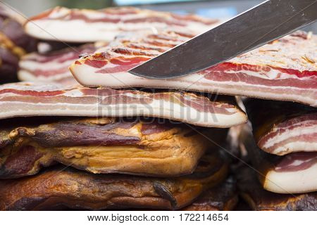 Home made smoked bacon in a street market selective focus and small depth of field