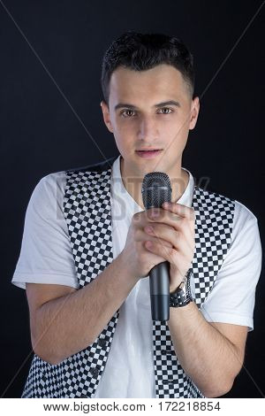Young Male Black-haired Singer Performs Singing To Microphone