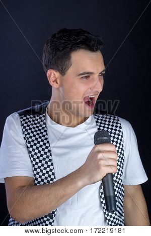 Young Male Black-haired Pop Singer Singing To Microphone