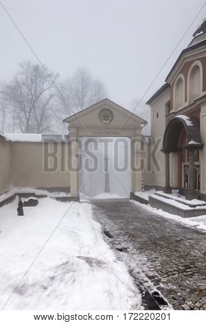 Old cross in front of the entrance to the International Shrine of St. Anna the winter fog. Mount St. Anna