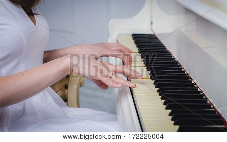 The girl plays the piano white color