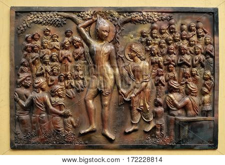 KOLKATA,INDIA - FEBRUARY 09: Plucking off the hair with his own hands and accepting the vow of renunciation, Street bass relief on the wall of Jain Temple (also called Parshwanath Temple) in Kolkata.