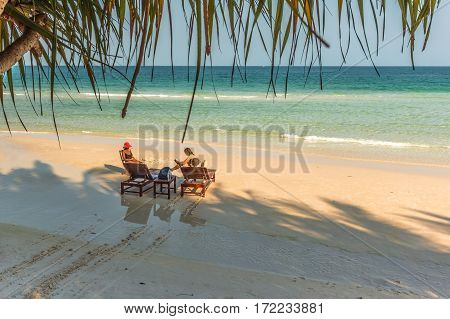 Tourists relax in the evening sunshine on a tropical beach Puh Quoc island Vietnam January 28 2014