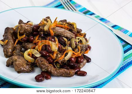 Beef liver, onions, carrots fried on palte. Studio Photo