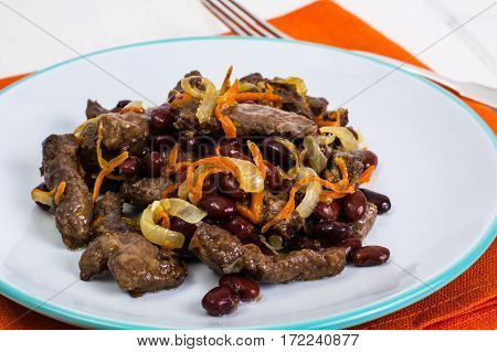 Beef liver, onions, carrots fried on palte. Studio Photo