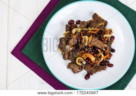 Beef liver, onions, carrots fried on palte. Studio Photo