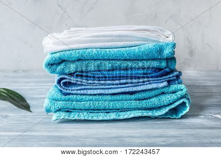 blue towels pile in housekeeping set on laudry gray background mock-up