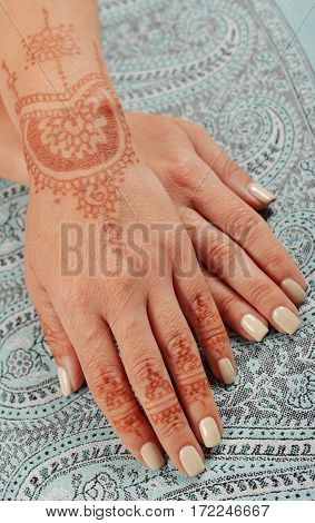 Woman hand with henna mehendi on indian shawl pashmina closeup