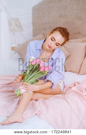 attractive female resting on the bed in the light bedroom