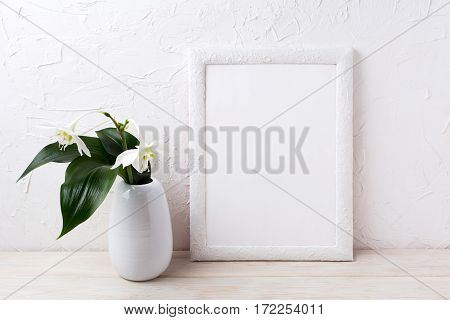 White frame mockup with euxaris flower in vase. Empty frame mock up for presentation artwork.