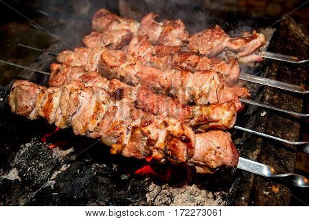 Cooking barbecue dish named shashlyk using skewers on mangal