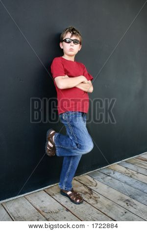 Child Leaning Against Dark Wall