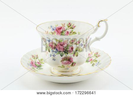 Empty antique cup and saucer with rose decoration isolated on white - English tea