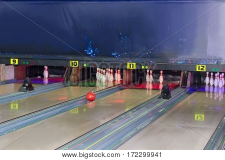 Fragment of several lanes rolling along the gutter bowling ball and bowling pins in a modern pin bowling alley