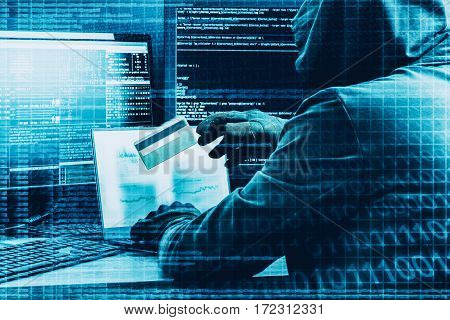 Internet concept. Hacker working on a code on dark digital background with digital interface around.