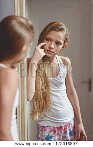 Teenage girl checking her face and body in the mirror