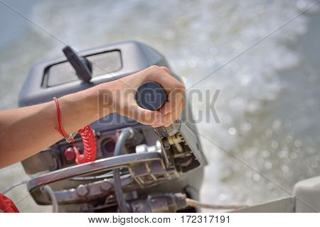 Fisherman hand and boat engine on river