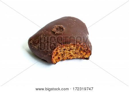 Chocolate covered gingerbread heart with a bite mark on a white background