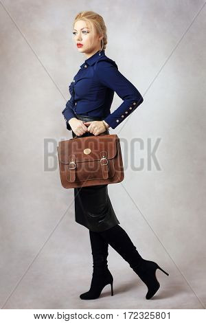 fashion model holding brown bag shot in light background in studio
