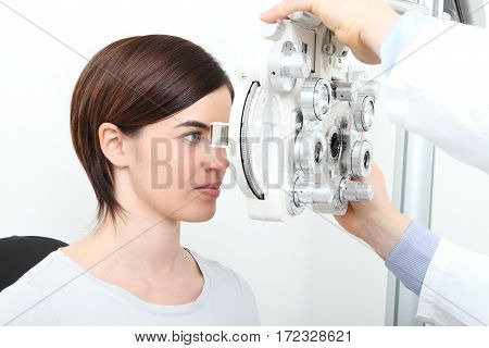 woman doing eyesight measurement with optical phoropter