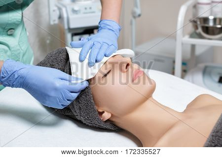 doctor cosmetologist cleanses the skin of woman after applying the mask. Perfect cleaning - cosmetic treatment for the care of the skin. Spa treatments