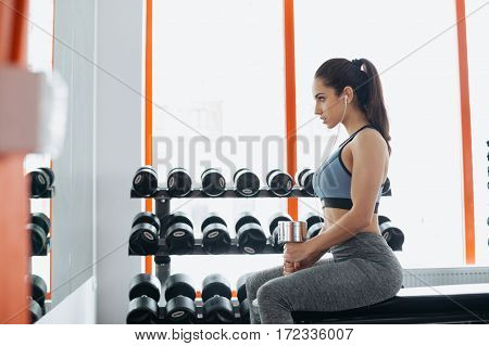 Beautiful Young Woman Exercising With Dumbbell In The Gym.
