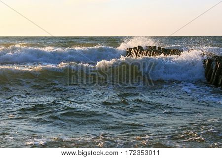 The waves of the Baltic Sea breaking on the old wooden german breakwater.